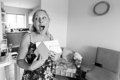 Bride makes happy face when reading card from the groom at Asylum Chapel wedding. 