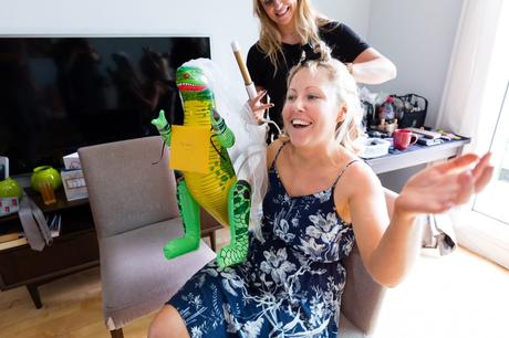 Bride holds blow-up dinosaur with a veil at London Asylum wedding. 