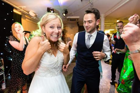 Bride gives thumbs up during evening dancing. 