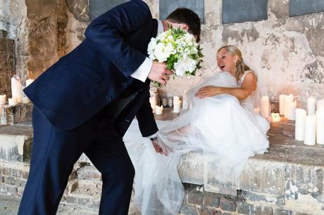 Bride laughs when shoe gets caught in her dress at Asylum wedding. 