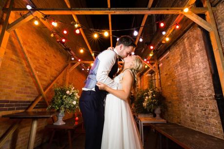 Wedding Photography at Asylum Chapel kiss under festoons at night. 