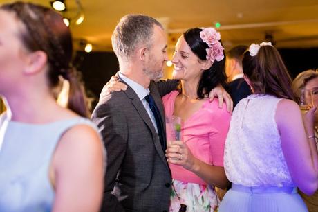 Guests smiling at each other at London wedding. 