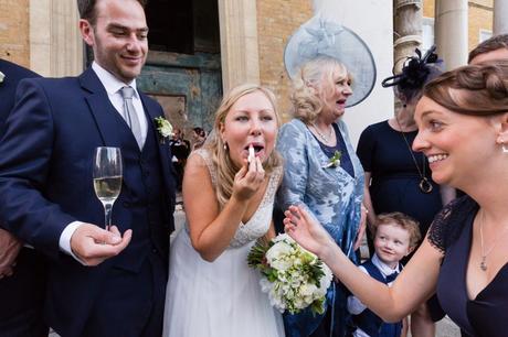 Bride puts on lipstick whilst the groom holds champagne glass. 