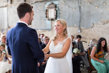 Bride and groom hold hands during the wedding ceremony at The Asylum. 