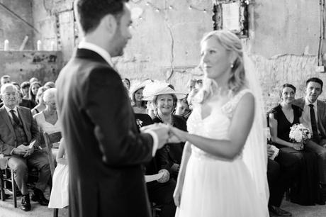 Bride's mother looks on during ring exchange at Asylum wedding. 