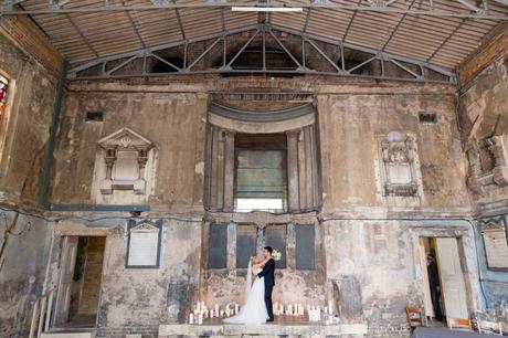 Wide shot of bride and groom inside Asylum wedding venue with crumbling walls. 