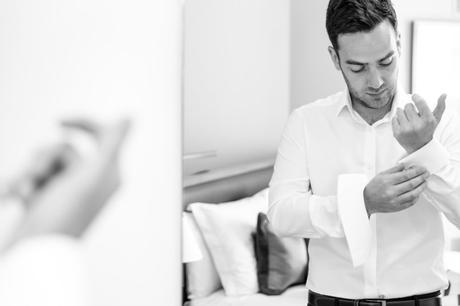 Groom buttons cuff links at Asylum wedding. 