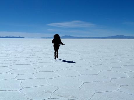 Girl on surface of salt lake Salar de Uyuni in Bolivia, South America