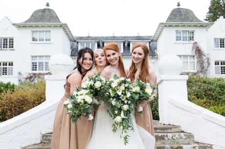 Redheaded bride having fun with bridemaids at Achnagairn Estate wedding on steps