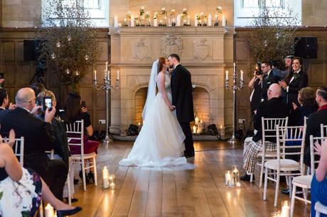 Bride & groom kiss in front of fireplace at Achnagairn Estate wedding. 