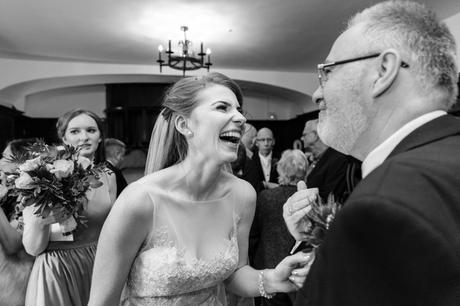Bride laughs and smiles with guests at Achnagairn Estate wedding candid