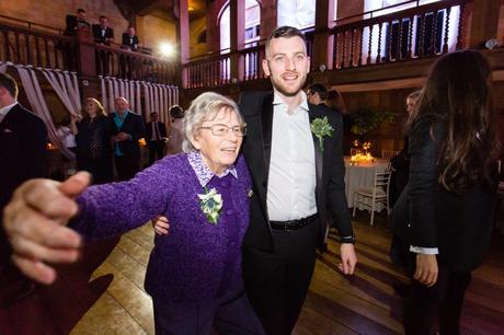 Grandmother dancing with groomsman at wedding. 
