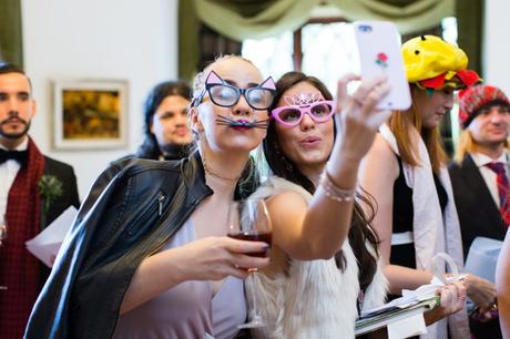 Guests making silly faces in photobooth with cat glasses