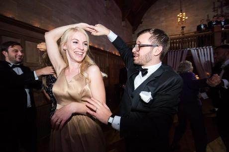 Groomsman in tuxedo with bow tie dancing at wedding. 
