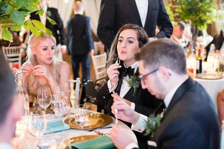 Groom'smaid blowing bubbles at a table. 