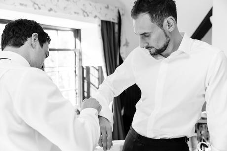 Groom's best man helps with cuff link