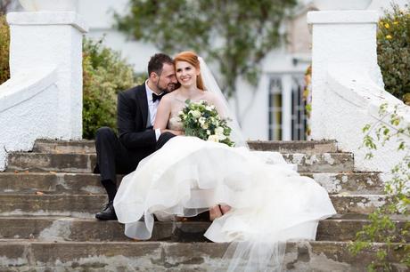 Wedding Photography at Achnagairn Estate couple with redheaded bride sitting on the steps and cuddling