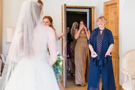 Bride's mother and bridesmaids seeing her for the first time. 