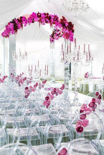 wedding trends 2019 ceremony under white tent with clean actylic chairs and arch with crimson orchid flowers katiebeverleyphoto