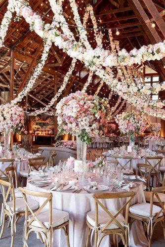 wedding trends 2019 elegant wedding reception in barn with tall centrpieces pale pink flower handing garlang larissaclevelandphoto