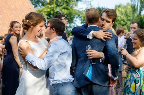 bride and groom hug their guests at their norfolk wedding