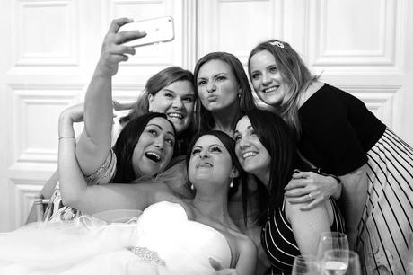 a bride and her guests take a selfie at hengrave hall
