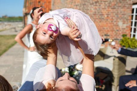 lifting up the flower girl at a cley windmill wedding