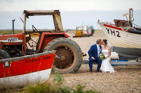 wedding portrait with the fishing boats on cley beach in north norfolk