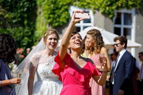 a guest takes a selfie with the bride