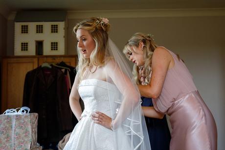 bridesmaids helping the bride dress