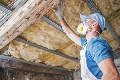 a workman inspecting roof insulation