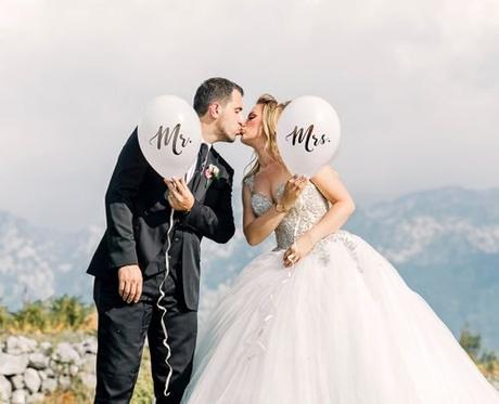 wedding announcement wording man and woman kissing while holding balloons