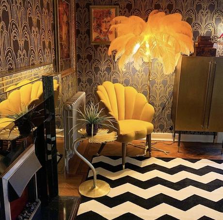 Gold ginkgo leaf occasional table styled in a glamorous and eclectic living room, with monochrome rug and ostrich feather floor lamp