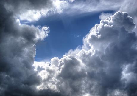 clouds in the sky with the sun peeking through them.