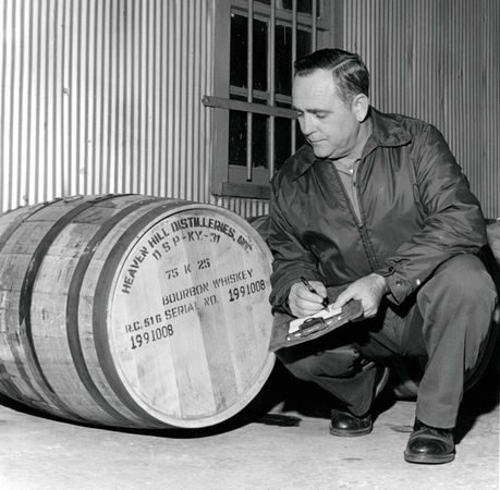 Earl Beam inspecting a barrel at the old Heaven Hill Distillery