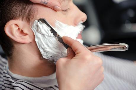 Client shaving at barber shop