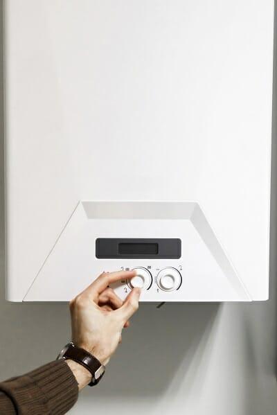 a man adjusting the output of a central heating boiler