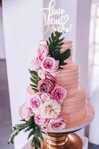 buttercream wedding cakes tall pink with flowers and leaves love sign on top justinandsimone