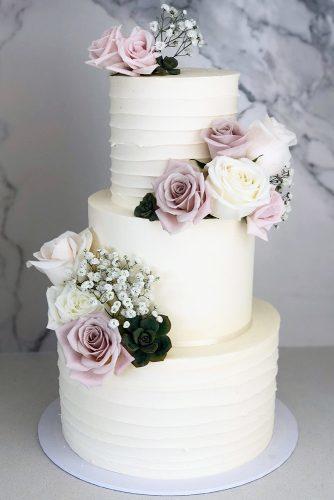 buttercream wedding cakes classic tall white with lilac roses and baby breath blondebakingmama via instagram