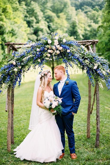 wedding colors classic blue pantone groom and bride under flower wedding altar hope helmuth photography