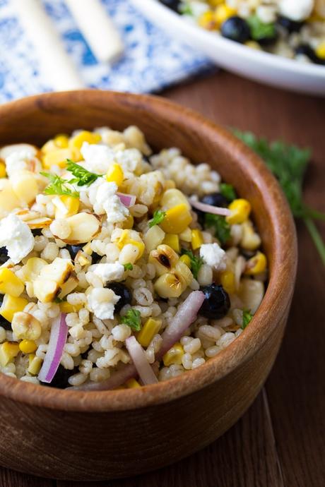 Summer Barley Salad with corn and blueberries in a wooden bowl