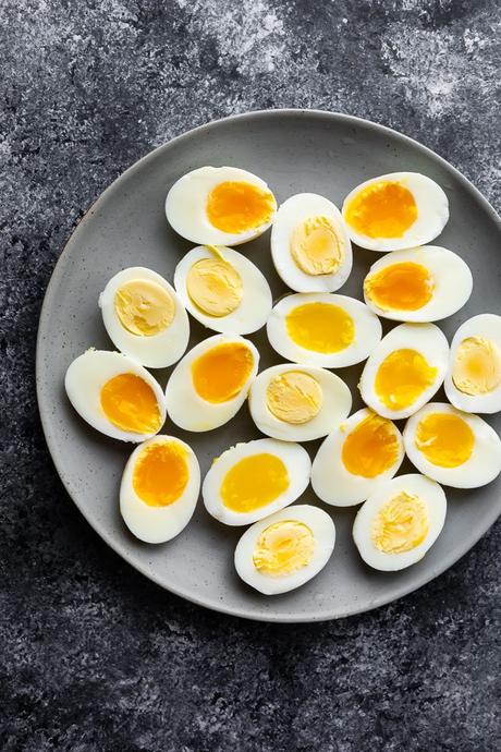 hard and soft boiled eggs cut in half and arranged on a plage