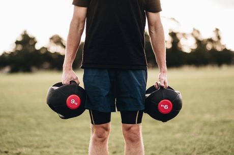 Person Holding Black Dumbbells