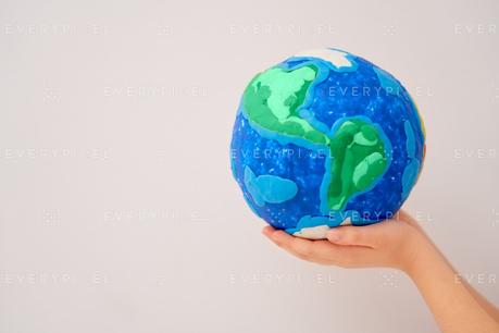 Child holding planet in hands against white background. Earth day holiday concept.