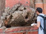 Travis confused with the lump of wood which thousands of coins have been nailed