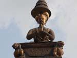 King Bhupatindra Malla column, the king sits with folded arms studying the magnificent golden gate to his palace
