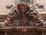 Intricately carved wooden windows, a Ganesh is seen above the entrance