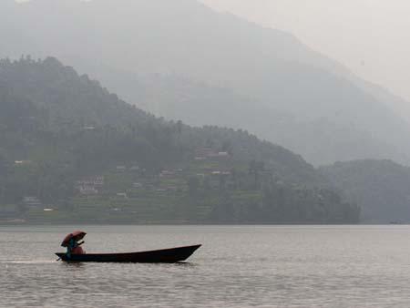 A lone Nepalese with canoe on Lake Phewa Tal