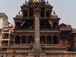 Krishna Mandir stone temple with shikhara-style spire, a Garuda kneels with folded arms on top of a column in front