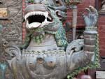 Metal snow lion at the entrance to a small Buddhist monastery